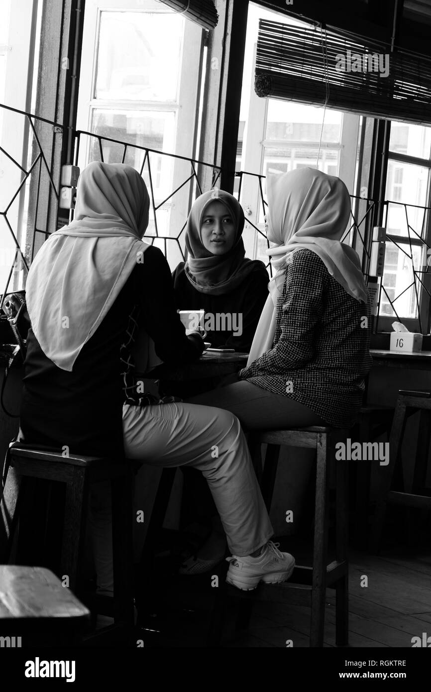 Trois femme musulmane indonésienne discuter dans le café Banque D'Images