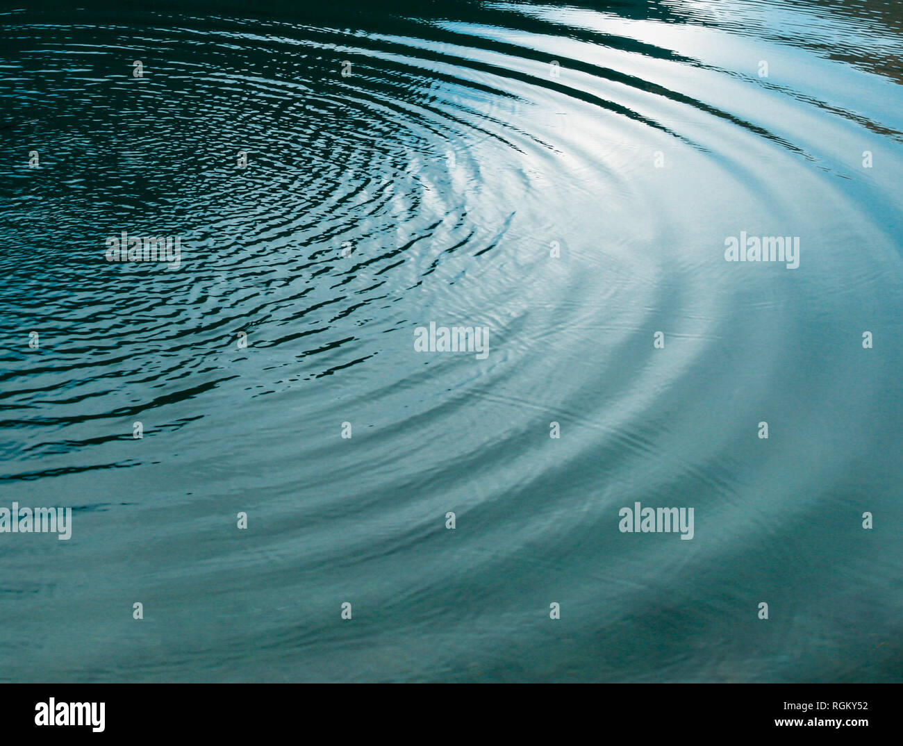 En forme de cercle de vagues sur le lac de l'eau claire. Résumé La texture, l'arrière-plan. Banque D'Images