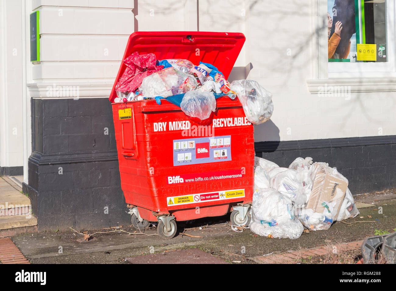 Bac de recyclage Biffa rouge débordante Banque D'Images