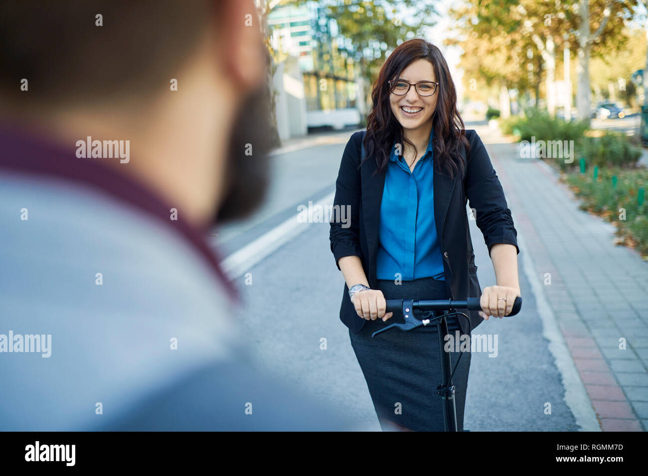 Smling businesswoman with scooter meeting businessman Banque D'Images