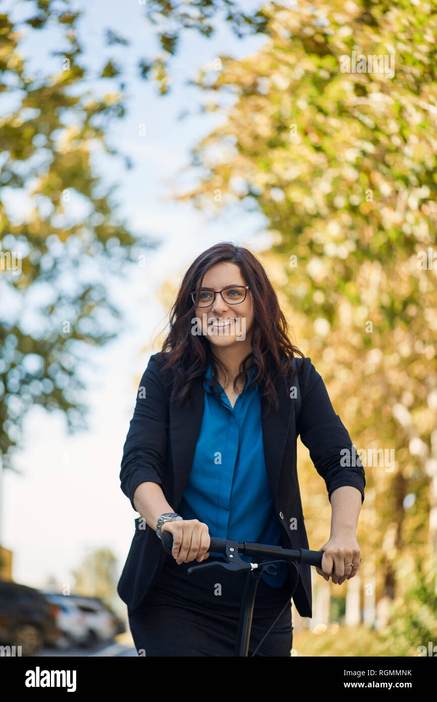 Portrait of smiling businesswoman with scooter Banque D'Images