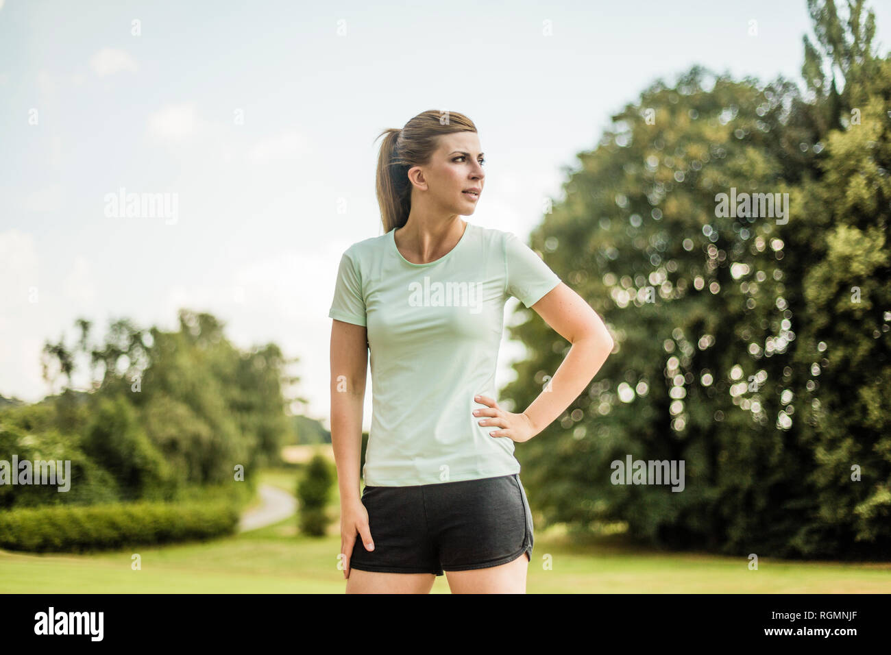 Jeune femme sportive debout dans un parc à côté Banque D'Images Jeune femme sportive debout dans un parc à côté Banque D'Images