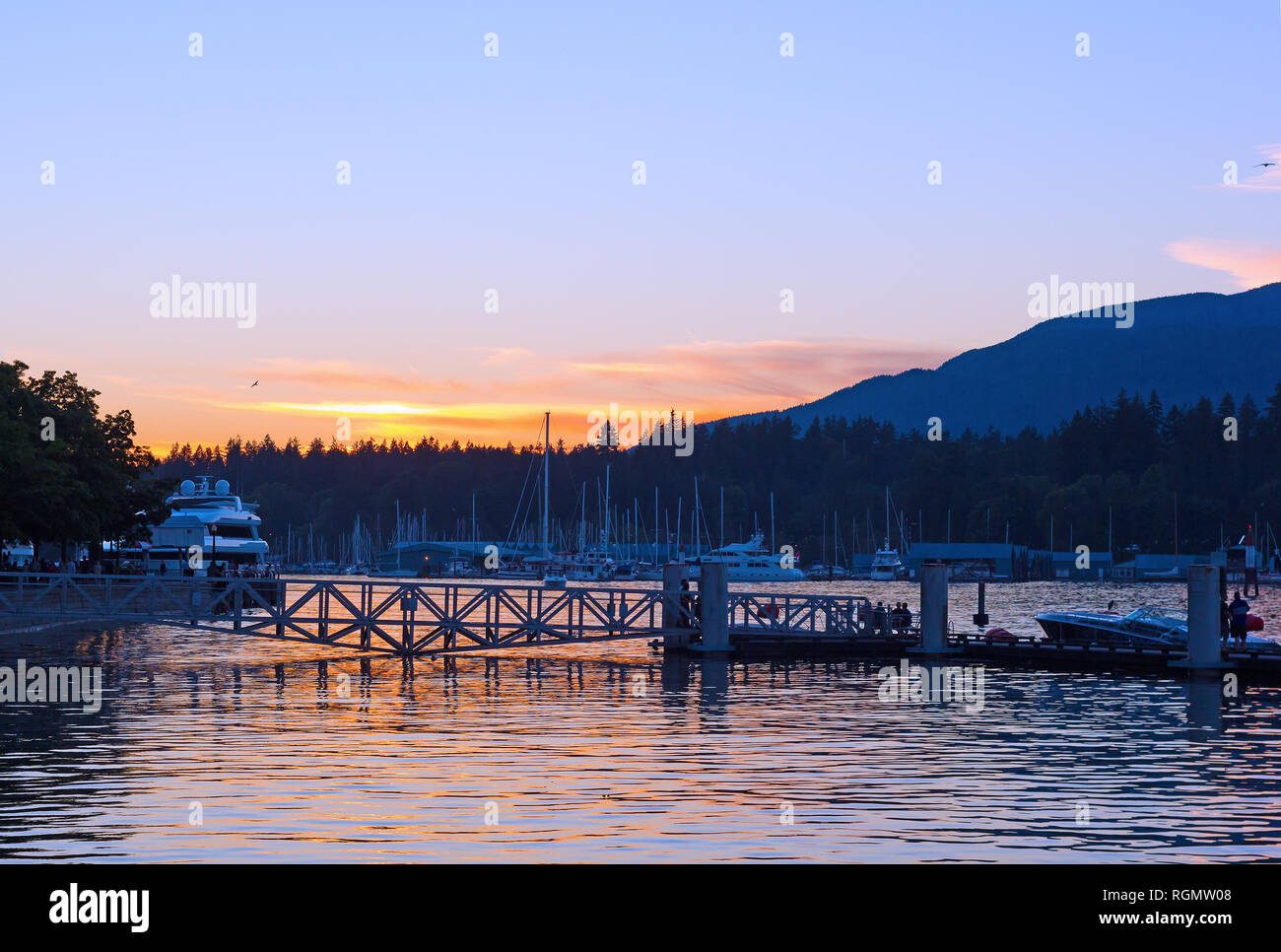 Le port de Vancouver avec les navires amarrés au coucher du soleil, Vancouver (C.-B.), Canada. Magnifique coucher de soleil avec un ciel clair, et les montagnes à l'horizon. Banque D'Images