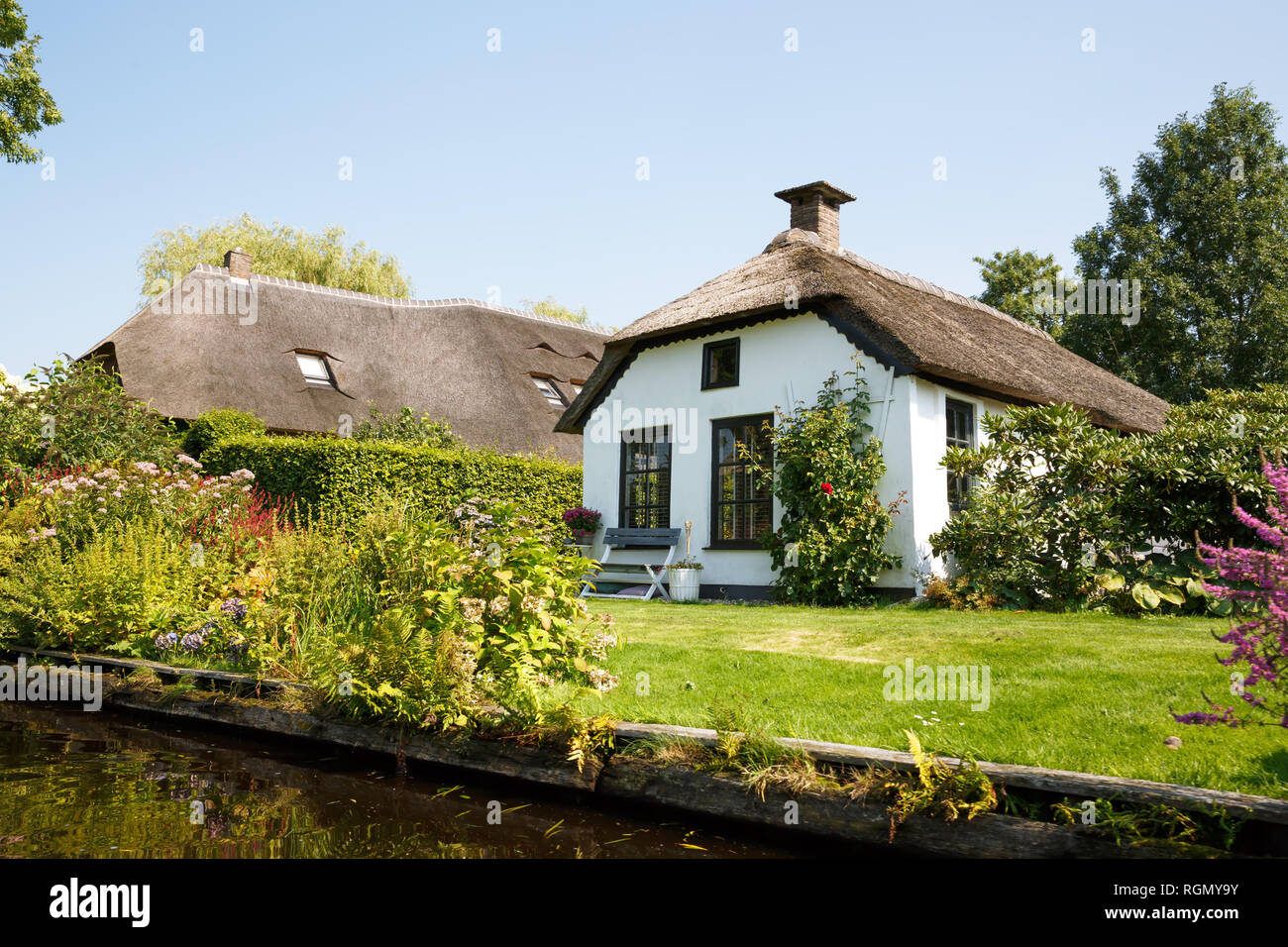 Le toit de chaume des maisons avec jardin, abri dans le village de conte de Giethoorn dans les Pays-Bas. Banque D'Images