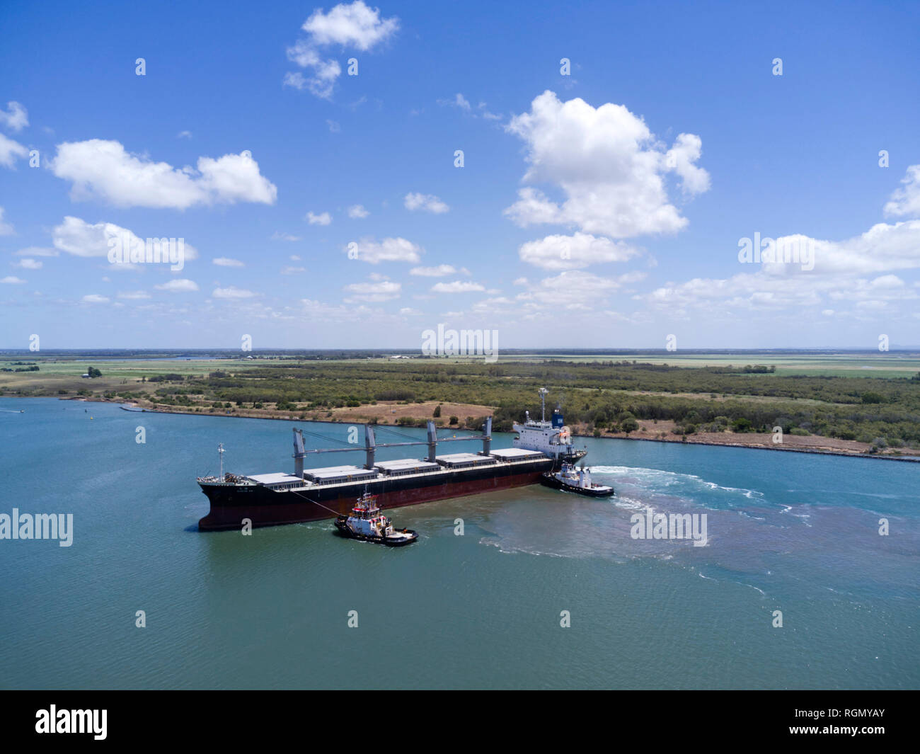 Navire vraquier aérienne sur la rivière Burnett d'amarrer à la borne du sucre avec l'aide de deux remorqueurs Australie Queensland Bundaberg Port Banque D'Images
