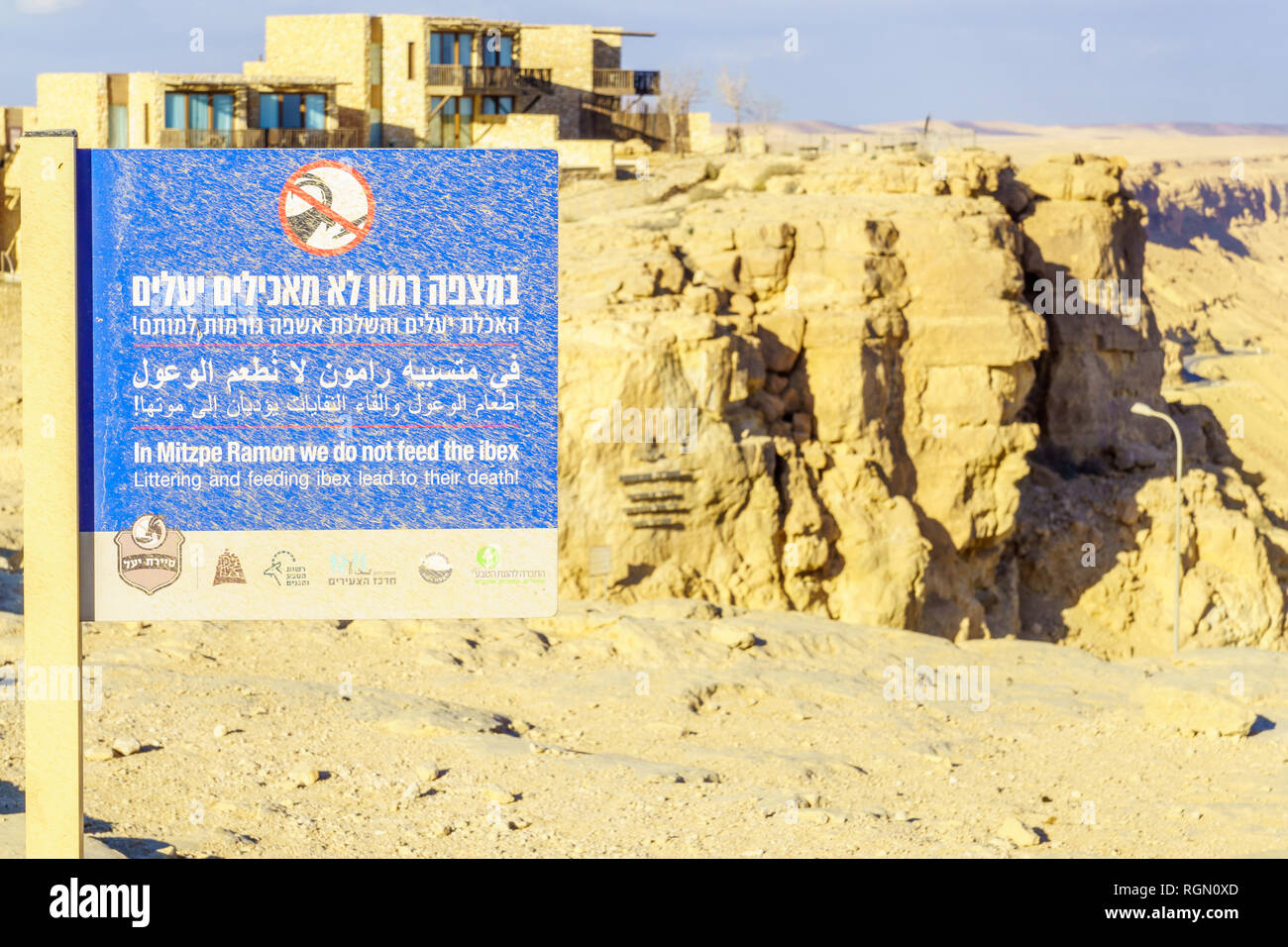 Mitzpe Ramon, Israël - 18 janvier 2019 : Dusty signer l'appel de ne pas nourrir le bouquetin, et le paysage de Makhtesh (cratère) Ramon, dans le désert du Néguev, au Sud Banque D'Images