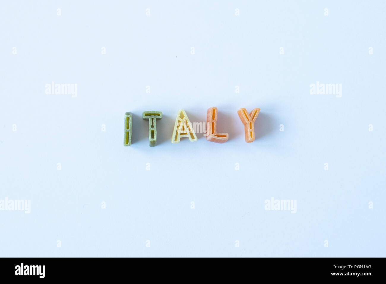 Le mot 'Italie' composé avec du vrai pâtes lettres dans le pavillon italien de couleurs sur une surface blanche. Ou fond d'arrière-plan. Banque D'Images