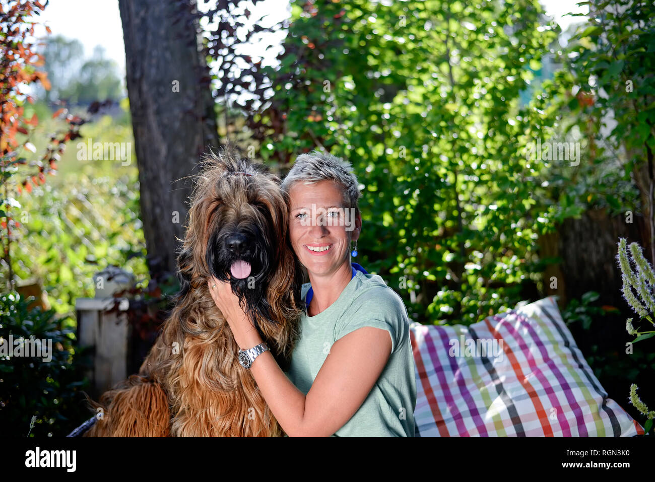 Portrait of smiling woman en tête à tête avec son chien dans le jardin Banque D'Images