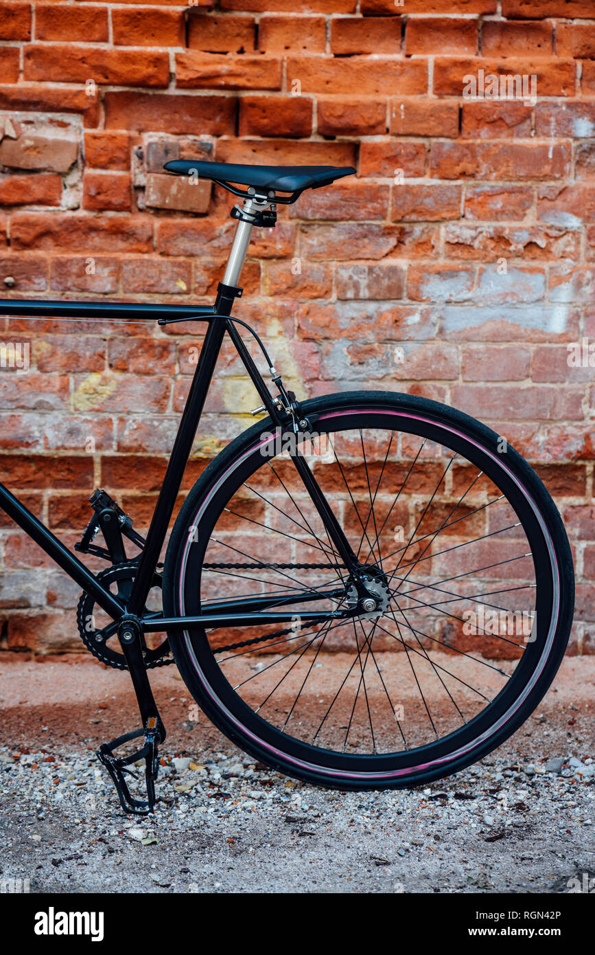 Détail d'un transport personnalisé fixie vélo au mur de brique Banque D'Images