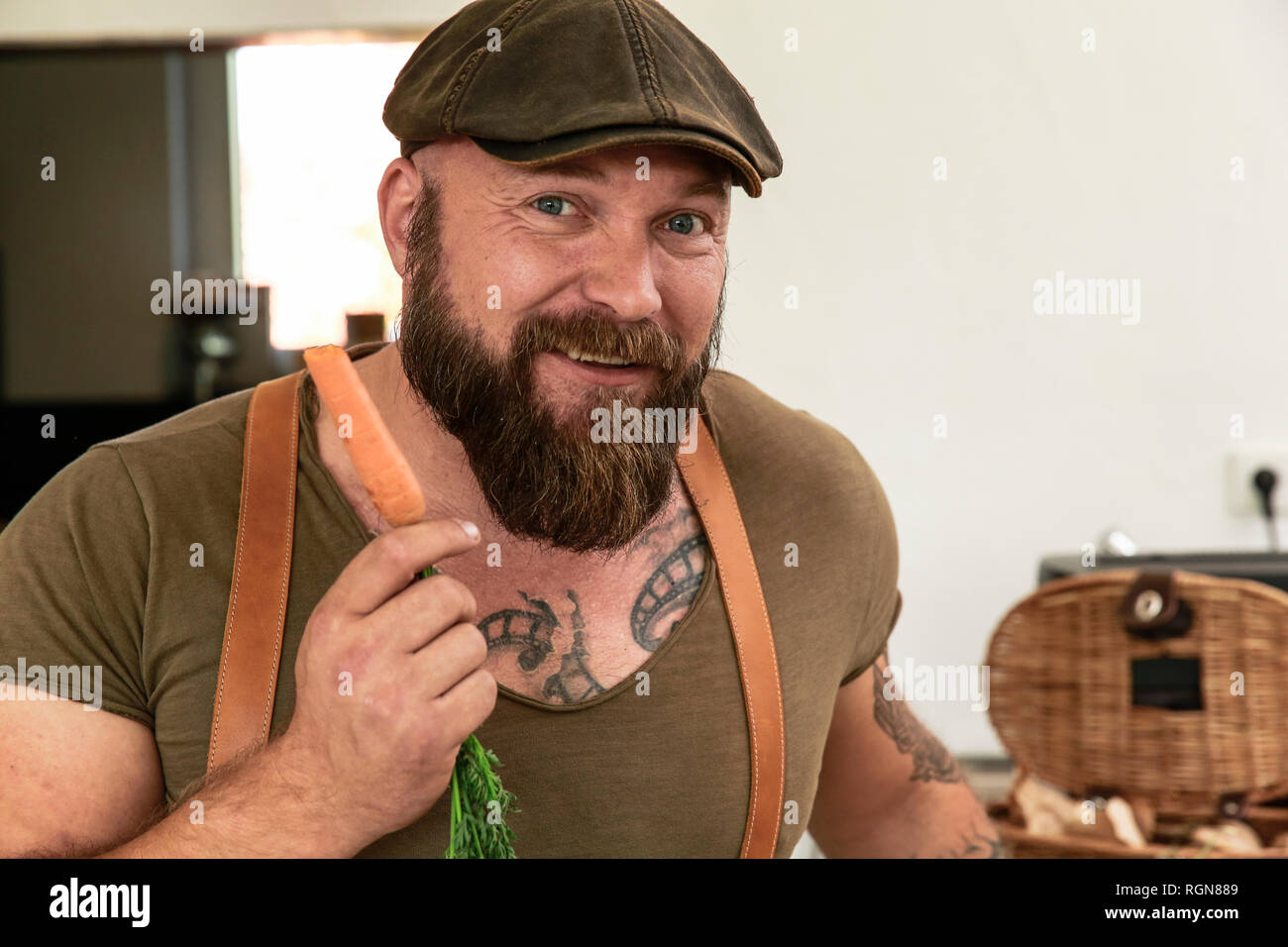 Man holding vegan carotte dans sa cuisine Banque D'Images