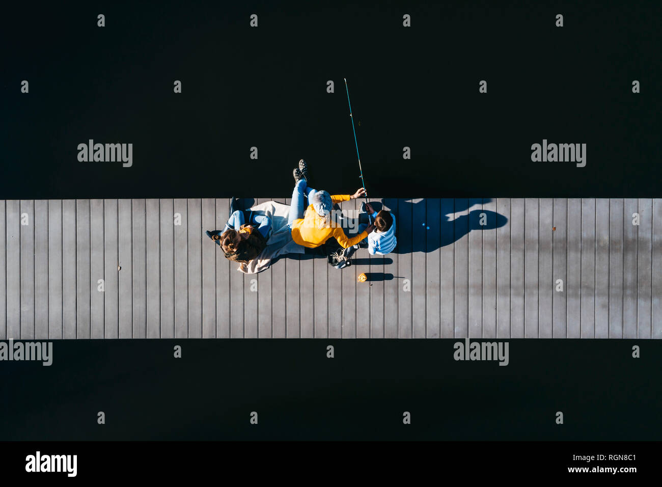 Family sitting on Jetty, pêche en autunm Banque D'Images