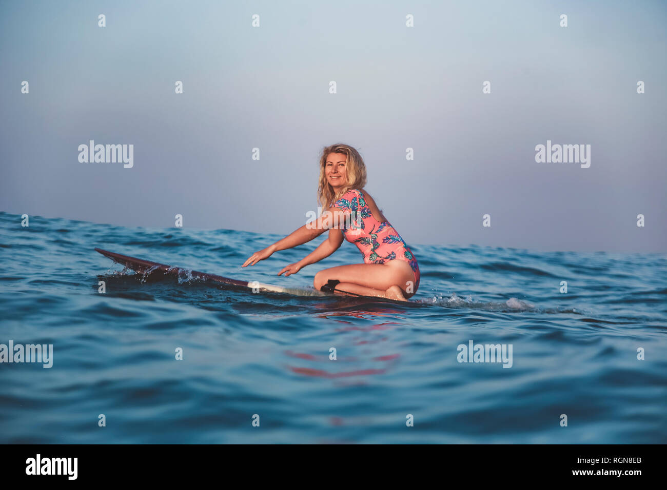 L'INDONÉSIE, Bali, pregnant woman sitting on surfboard Banque D'Images
