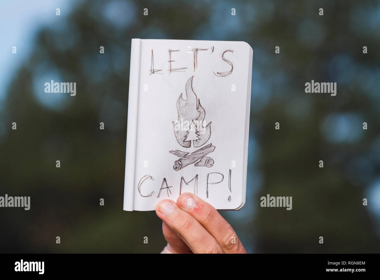 La main dans une forêt holding "Let's Camp' sign Banque D'Images