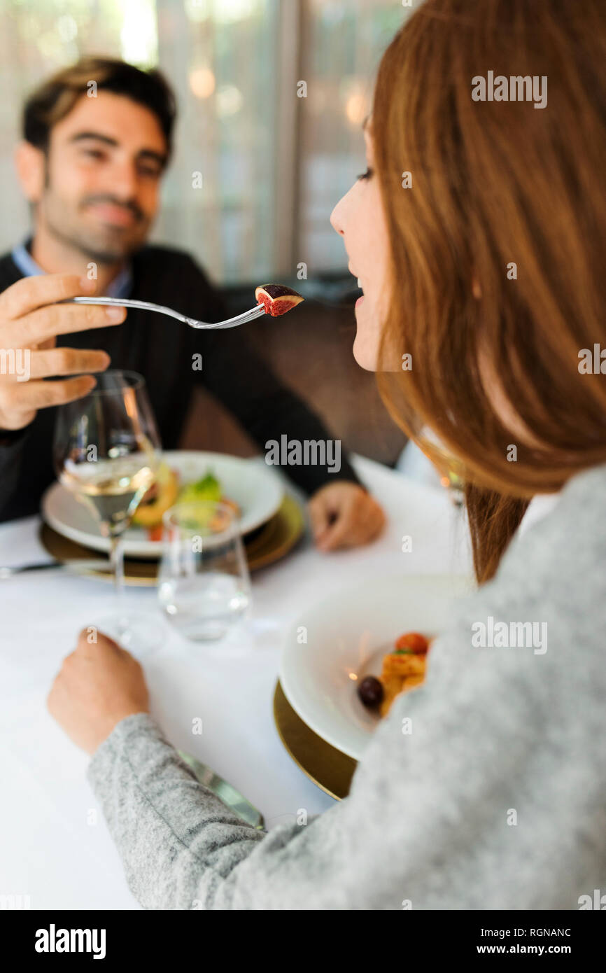 Mman laisser goûter la femme la nourriture dans un restaurant. Banque D'Images