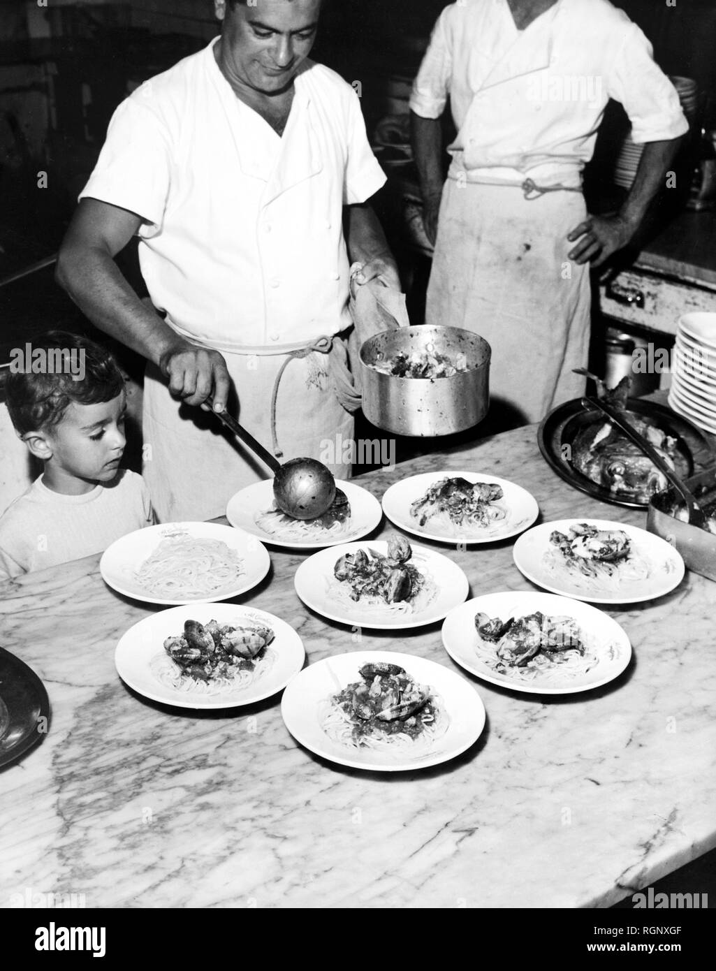 Chef preparing spaghetti aux fruits de mer, restaurant des Pouilles, 1965 Banque D'Images