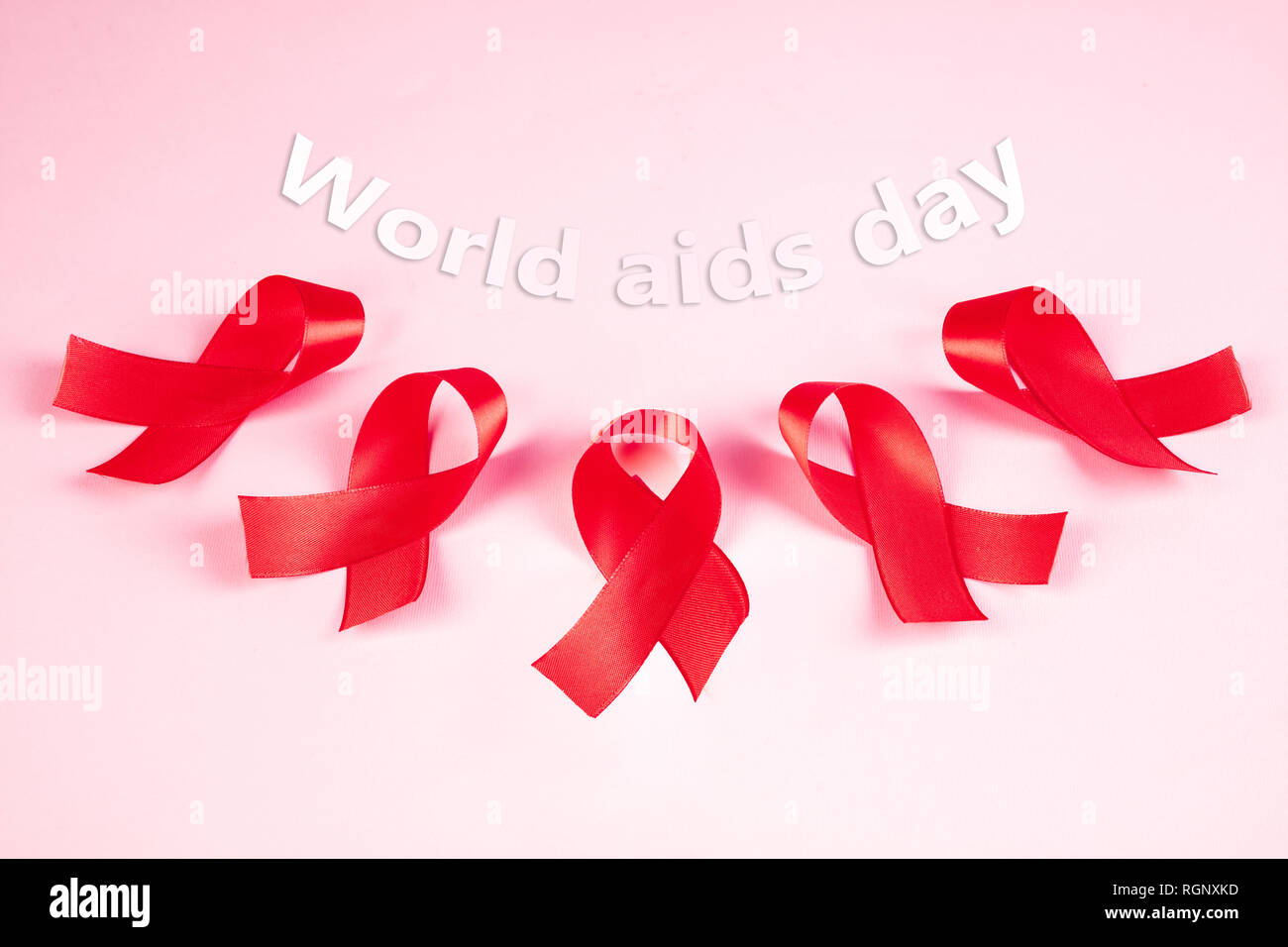 Signe de sensibilisation au sida de rubans rouges sur fond rose . Concept  de la Journée mondiale du sida. La santé, l'aide, de soins, de soutien,  d'espoir, de maladie, de soins de
