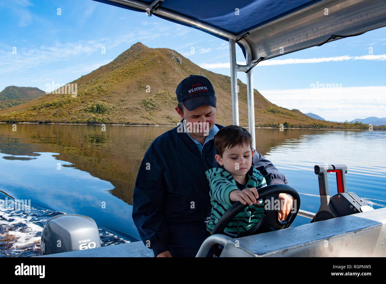 La conduite d'un garçon bateau sur le port de Bathurst, au sud-ouest de la Tasmanie, Australie Banque D'Images