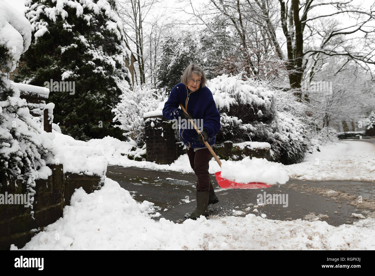 Sarah Filcek la neige pelles à l'extérieur de Buxton, Derbyshire, comme la Grande-Bretagne se prépare pour la nuit la plus froide de l'hiver jusqu'à présent, avec des chutes de neige significative susceptible d'entraîner de nouveaux retards de voyage et les fermetures d'école. Banque D'Images