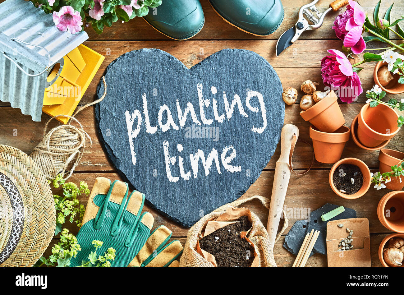 Plantant time concept avec matériel de jardin, des outils, des gants et des pots de fleurs, en forme de cœur avec tableau noir et craie signe, vu du dessus en ful Banque D'Images