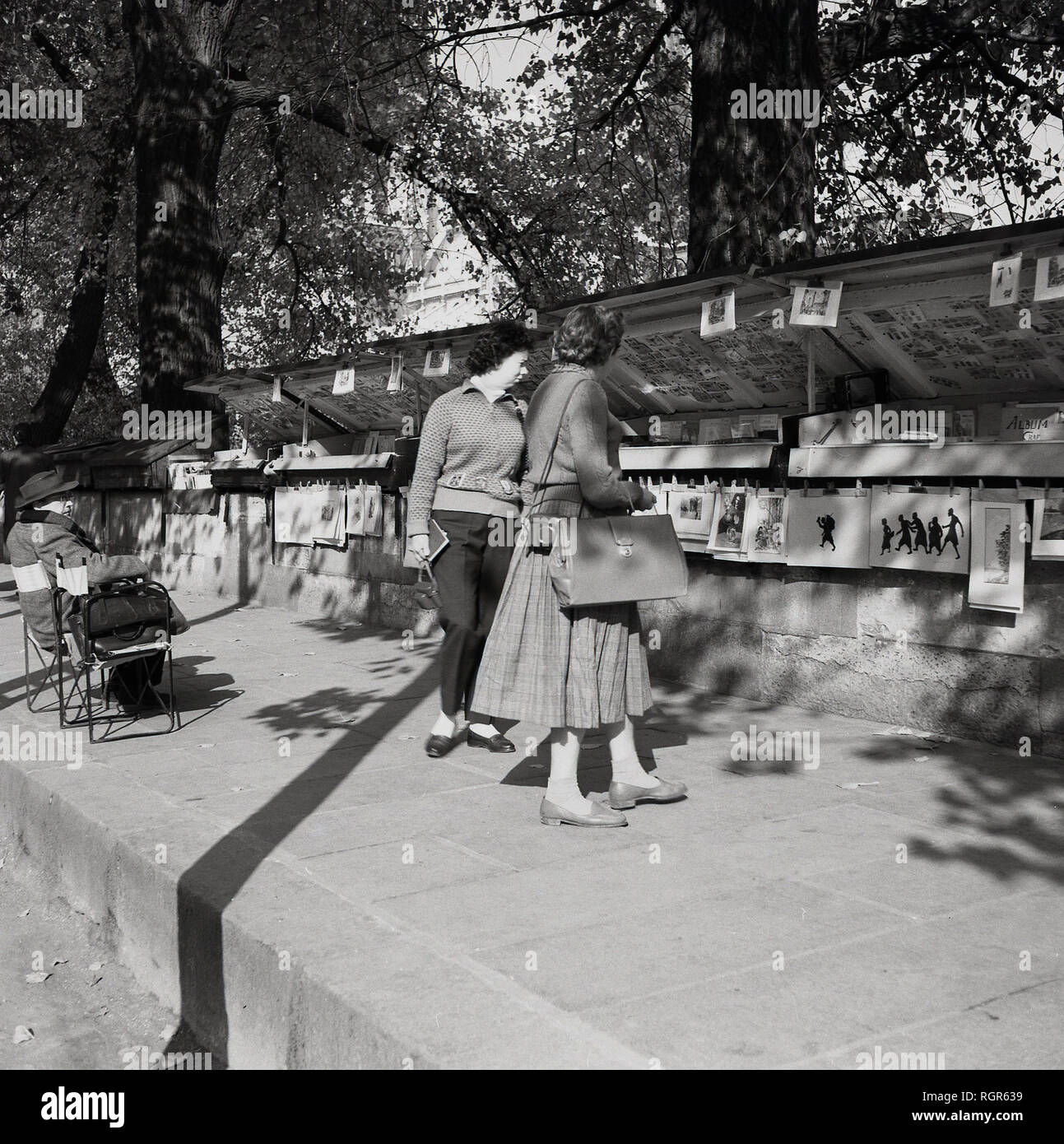Années 1950, historique, Paris, bouquinistes, deux dames parcourt l'une des attractions célèbres de la ville, le plein-air et des étals de livres anciens que le commerce par la Seine. Banque D'Images