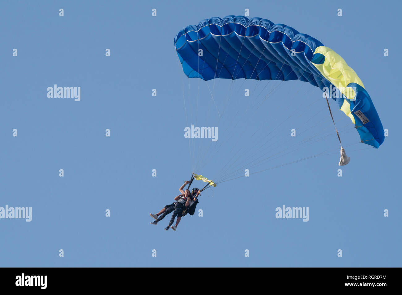Dubaï, Émirats arabes unis - 16 Février 2018 : Tandem skydivers effectuant le parachutisme avec des parachutes et bleu ciel ouvert À DUBAÏ, ÉMIRATS ARABES UNIS Banque D'Images