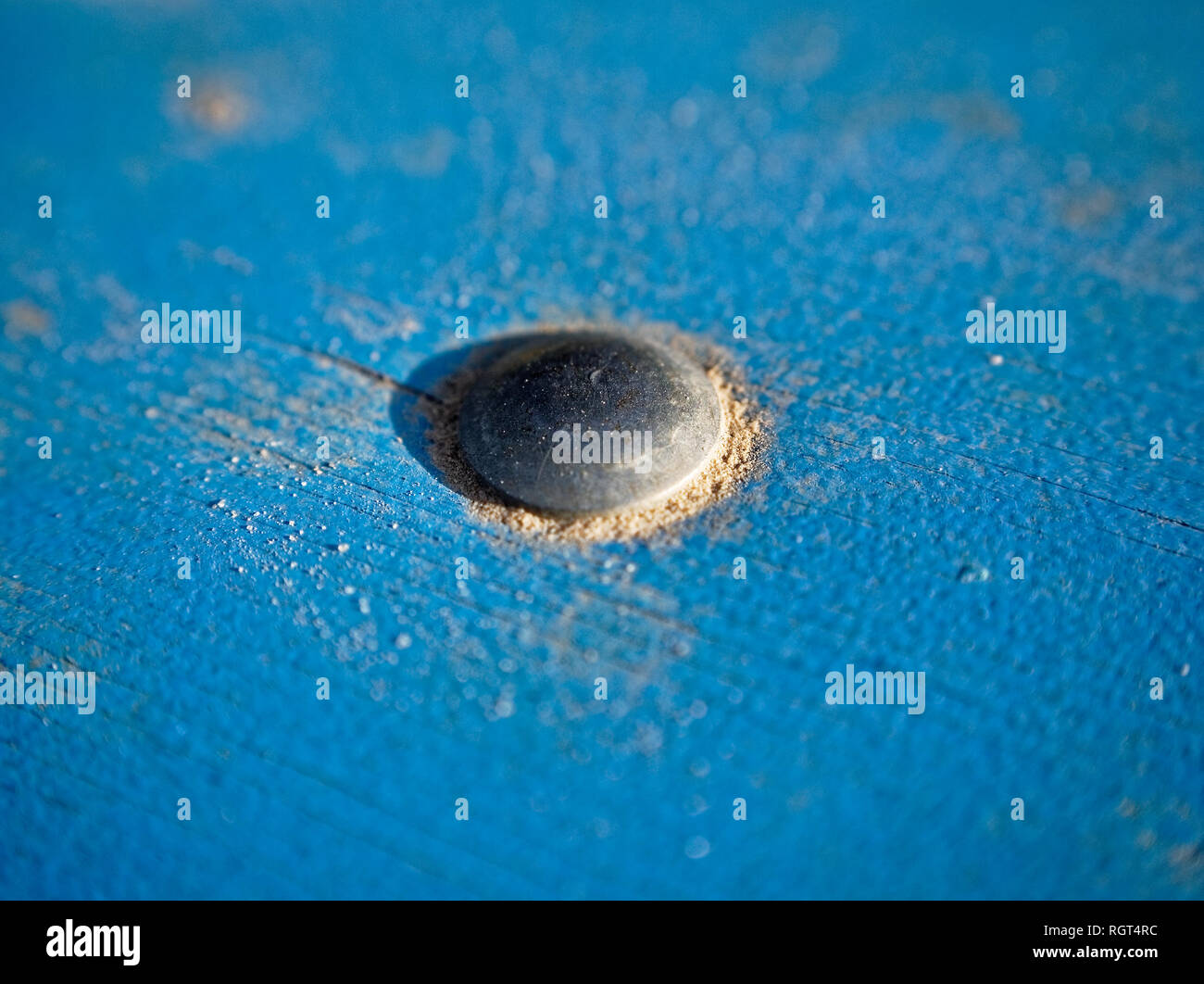 Le sable sur le panneau bleu, vis, close-up Banque D'Images