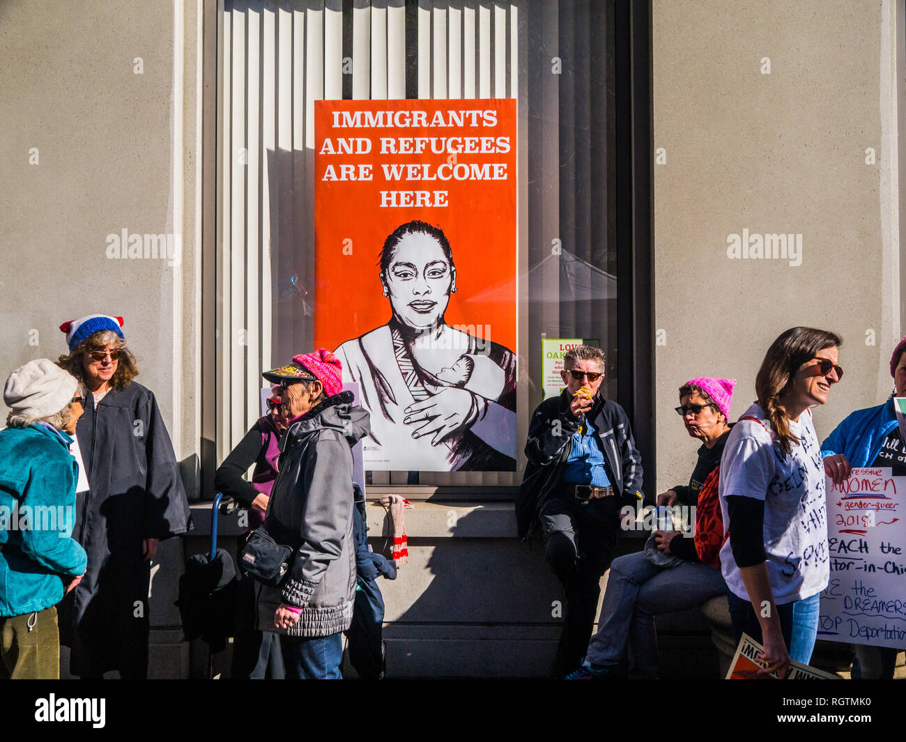 OAKLAND, CA/USA - 20 janvier 2018 : inscription se lit "les immigrés et les réfugiés sont les bienvenus ici" alors que les participants non identifiés à pied par à la Marche des femmes Banque D'Images