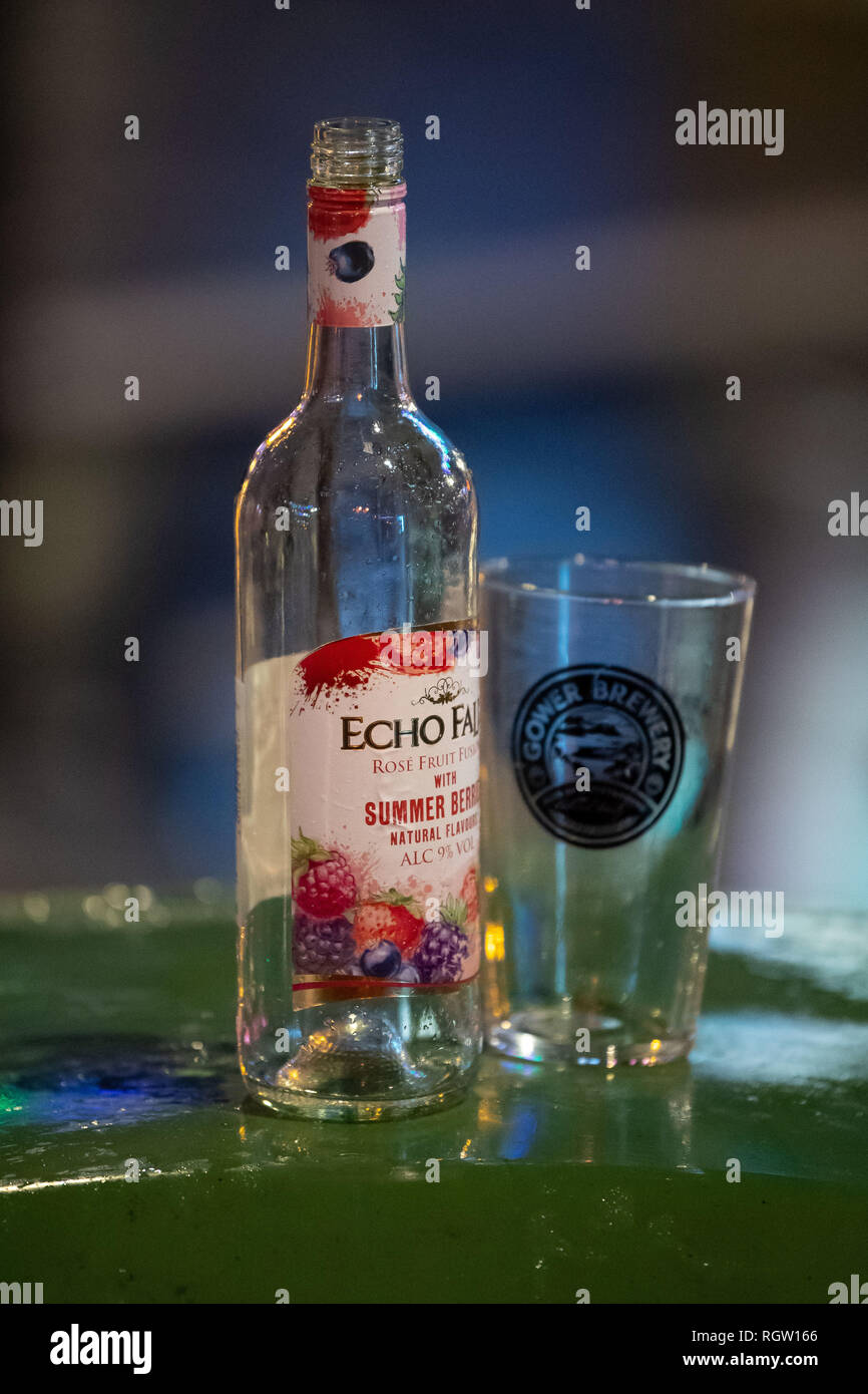 Une bouteille vide d'Echo Falls l'alcool sur un couvercle de bac le soir à Cardiff, Pays de Galles, Royaume-Uni. Banque D'Images