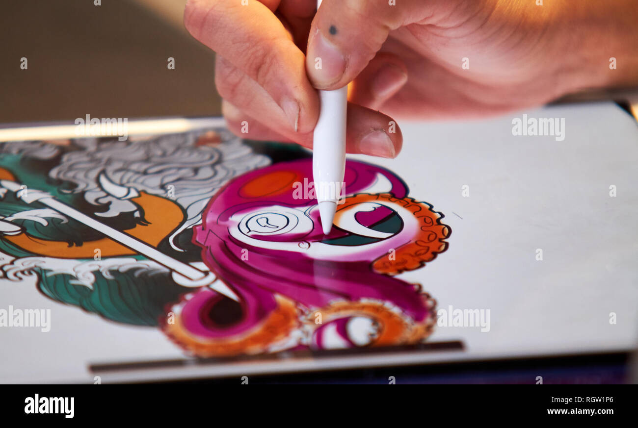 CIRCA 2018 ALICANTE JUSTE TATOUAGE tatoueur dessiner un croquis sur une tablette avec un stylo Banque D'Images