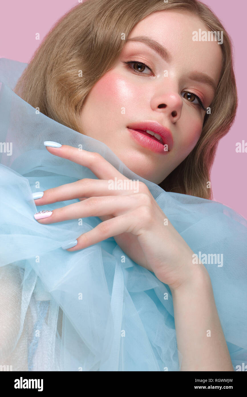 Belle fille avec la lumière douce et de maquillage manucure en bleu vêtements. Beauté Visage. Ongles Design. Banque D'Images