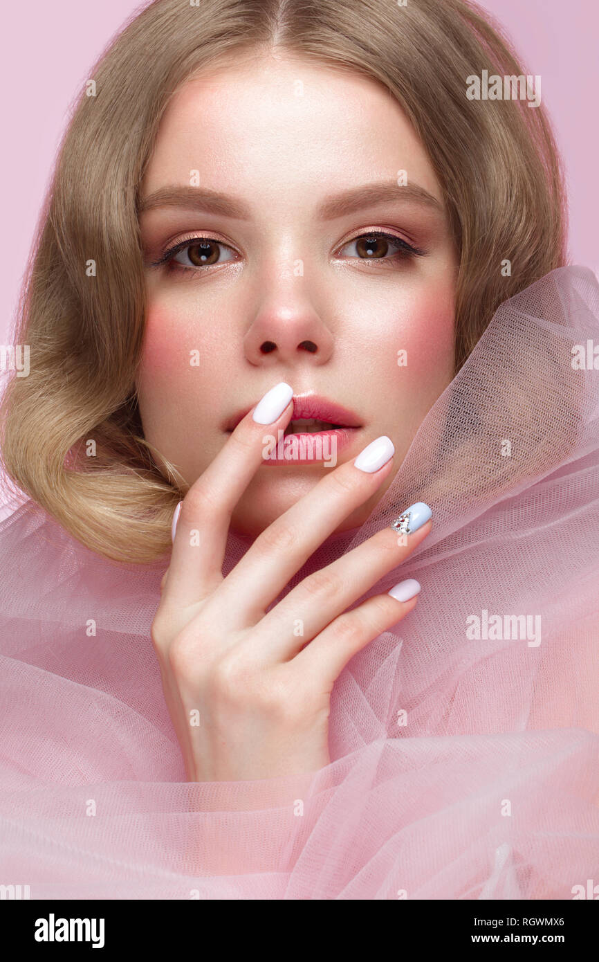 Belle fille avec la lumière douce et de maquillage manucure en vêtements rose. Beauté Visage. Ongles Design. Banque D'Images