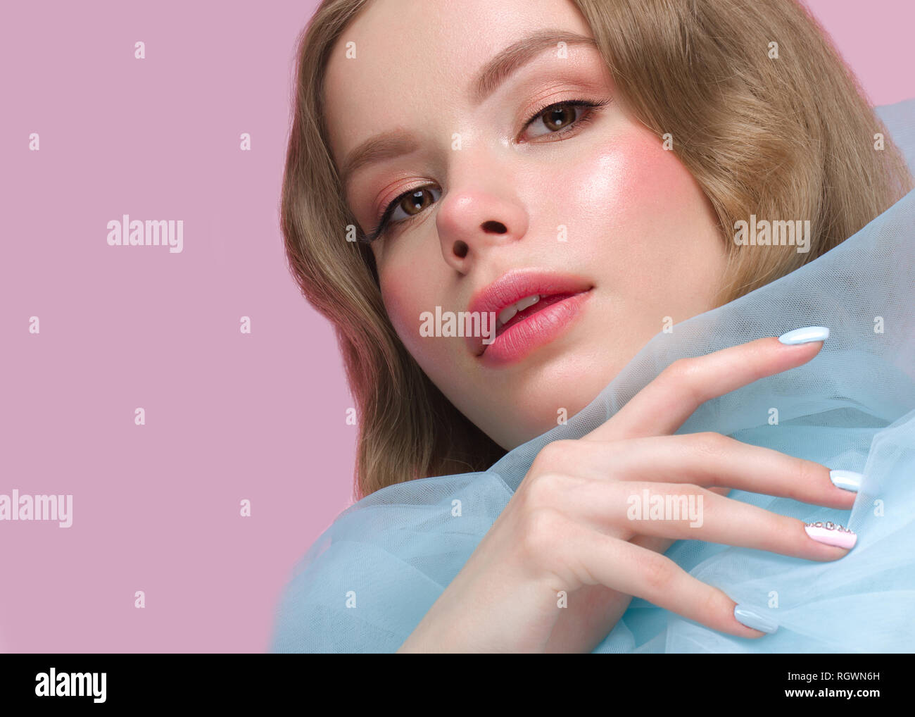 Belle fille avec la lumière douce et de maquillage manucure en bleu vêtements. Beauté Visage. Ongles Design. Banque D'Images