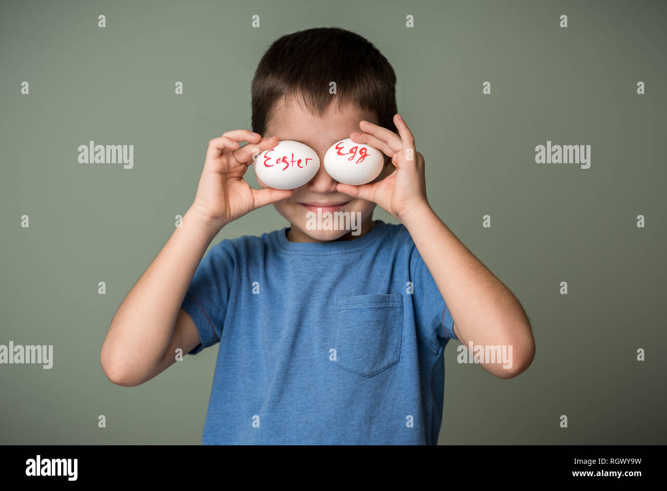 Les œufs de Pâques avec l'inscription dans les mains d'un enfant. Fond vert. Idées de Pâques. L'espace pour le texte. Lettrage de corail vivant. Joyeuses Pâques. Banque D'Images