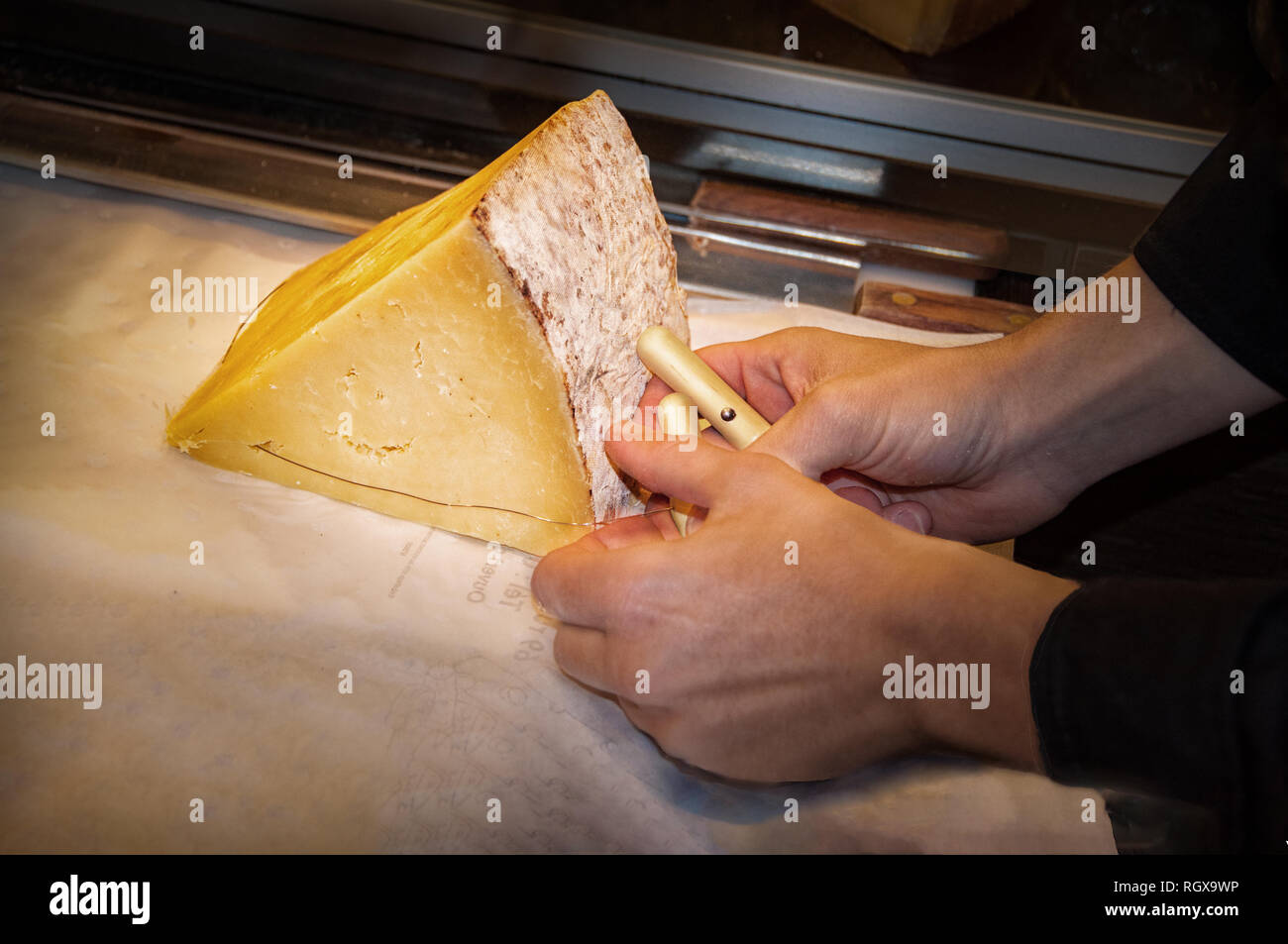 En utilisant le fil traditionnel fromage monger avec deux petites poignées pour le morceau de fromage Emmental Banque D'Images