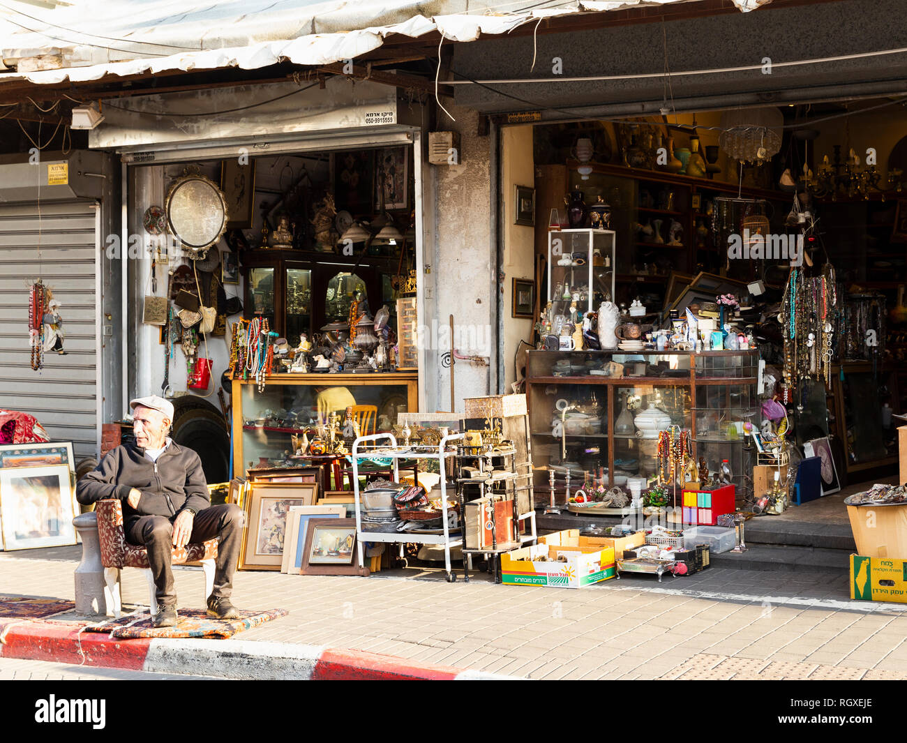 La vieille ville de Jaffa, Tel Aviv, Israël - 23 décembre 2018 : un vieux vendeur assis dans un fauteuil en face de son magasin d'antiquités dans le célèbre marché aux puces de la vieille ville de Jaffa, Banque D'Images