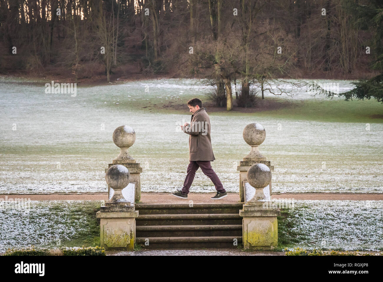 Manchester, UK - 30 janvier 2019 - - un homme marche à travers champs couverts de neige de Priory Park à Reigate, UK, par un froid matin d'hiver Banque D'Images