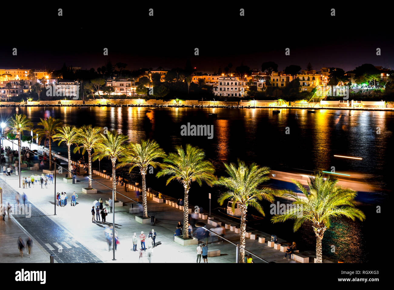 Les touristes et les habitants profitez d'une fin de nuit sur la promenade promenade au port de Brindisi dans la région des Pouilles en Italie. Banque D'Images