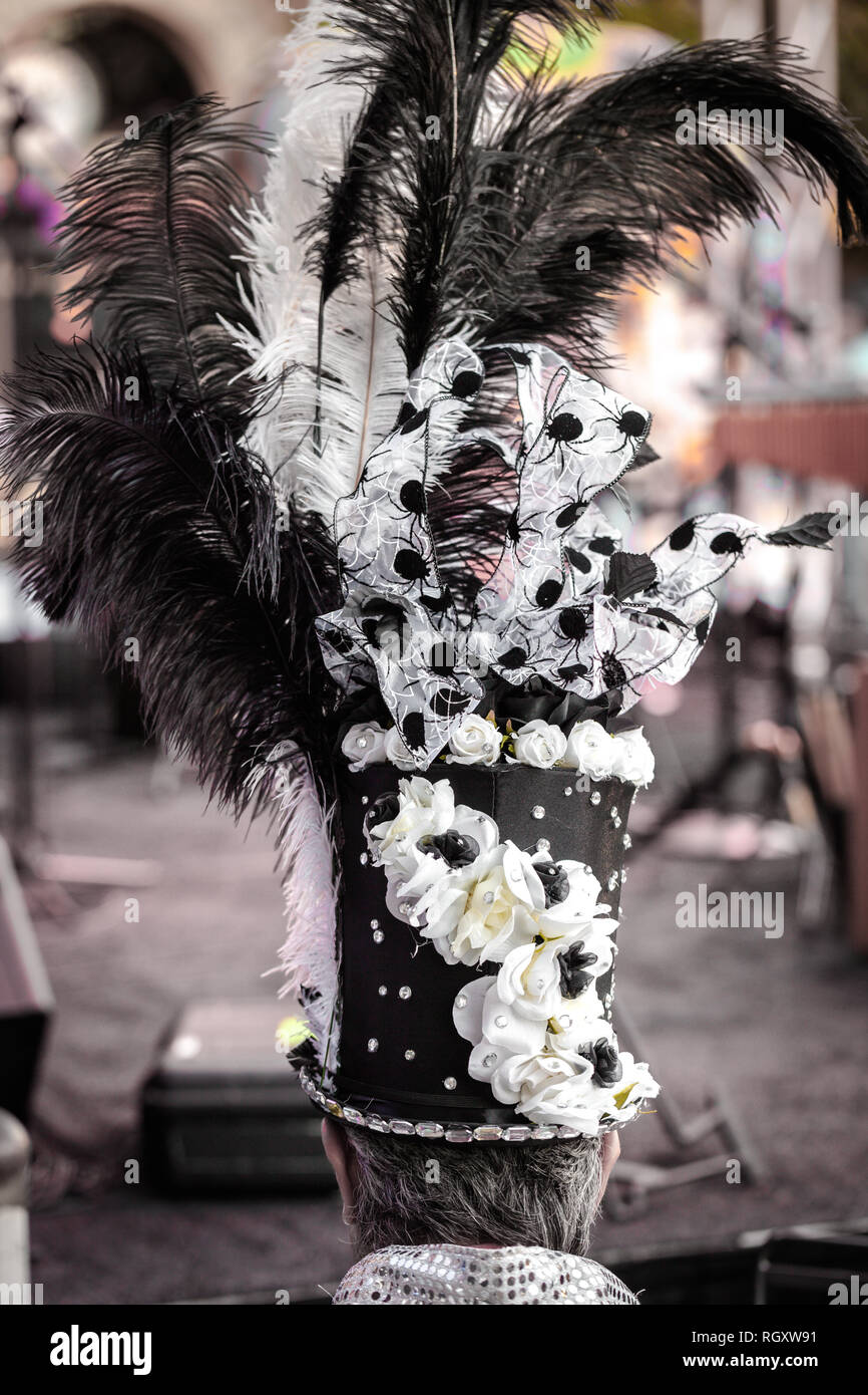 Vue arrière d'un homme portant chapeau haut de forme ou un cylindre décoré avec des plumes durinf un festival masqué Banque D'Images Vue arrière d'un homme portant chapeau haut de forme ou un cylindre décoré avec des plumes durinf un festival masqué Banque D'Images