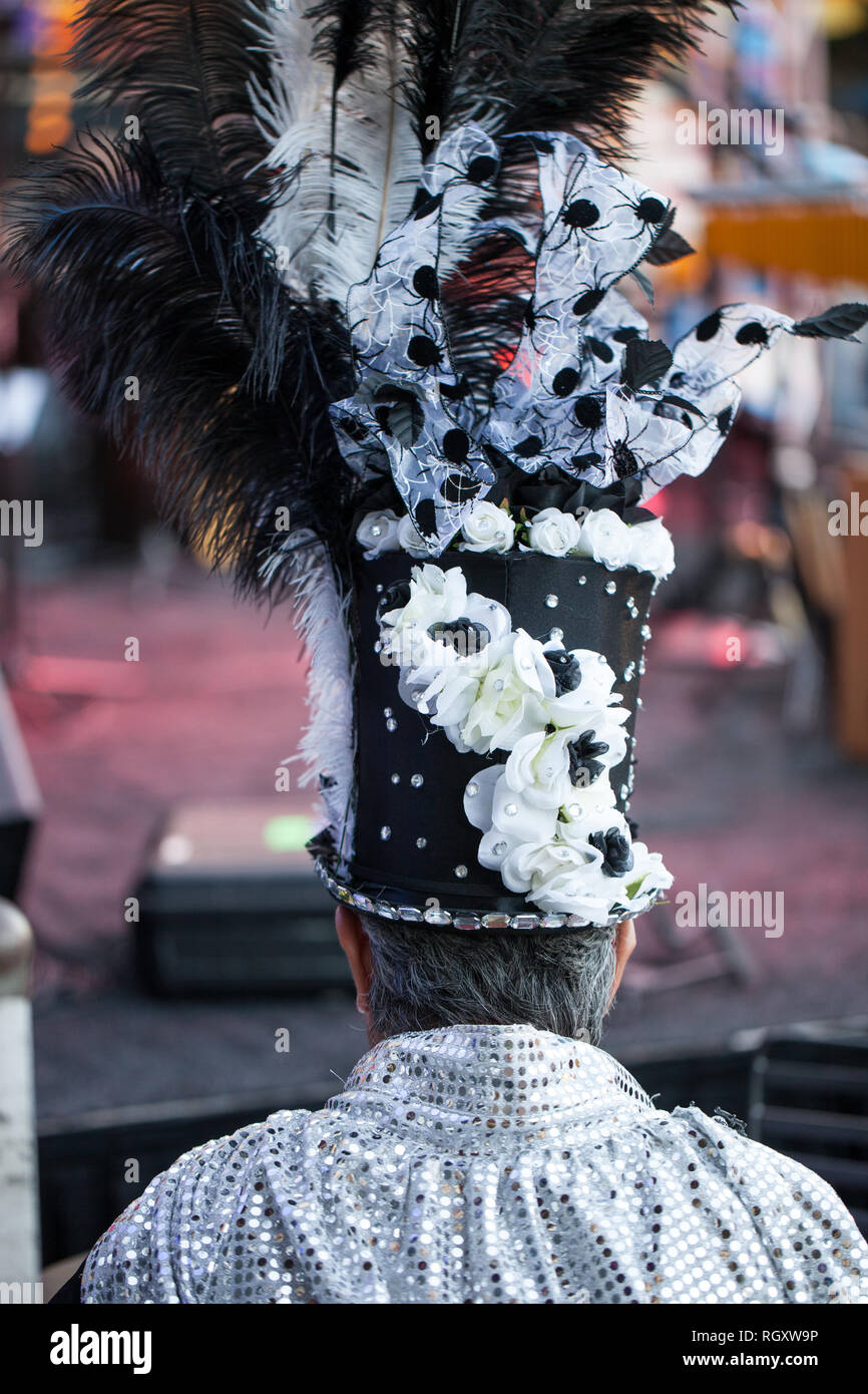 Vue arrière d'un homme portant chapeau haut de forme ou un cylindre décoré avec des plumes durinf un festival masqué Banque D'Images Vue arrière d'un homme portant chapeau haut de forme ou un cylindre décoré avec des plumes durinf un festival masqué Banque D'Images