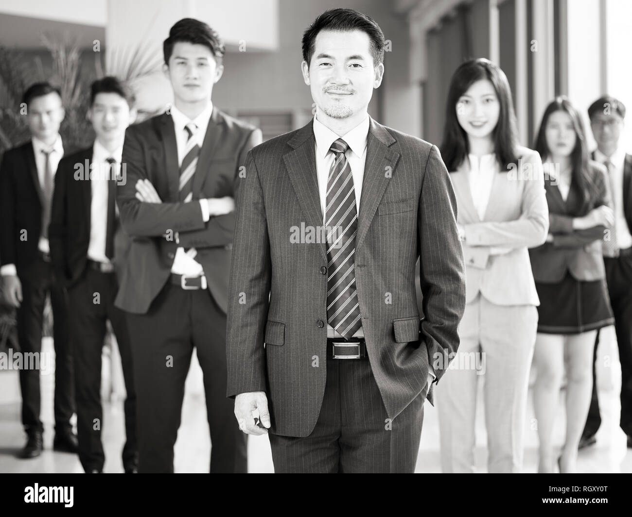 Portrait d'une équipe d'hommes et de femmes d'affaires asiatiques, smiling, noir et blanc. Banque D'Images