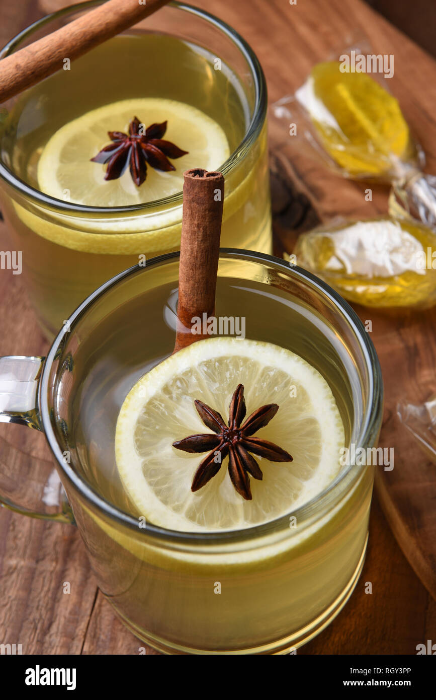 Vue de dessus de deux tasses en verre Toddys sur une table en bois sombre. Tranche de citron, l'anis étoilé et le bâton de cannelle sont dans la tasse avec des cuillères de miel dans le Banque D'Images