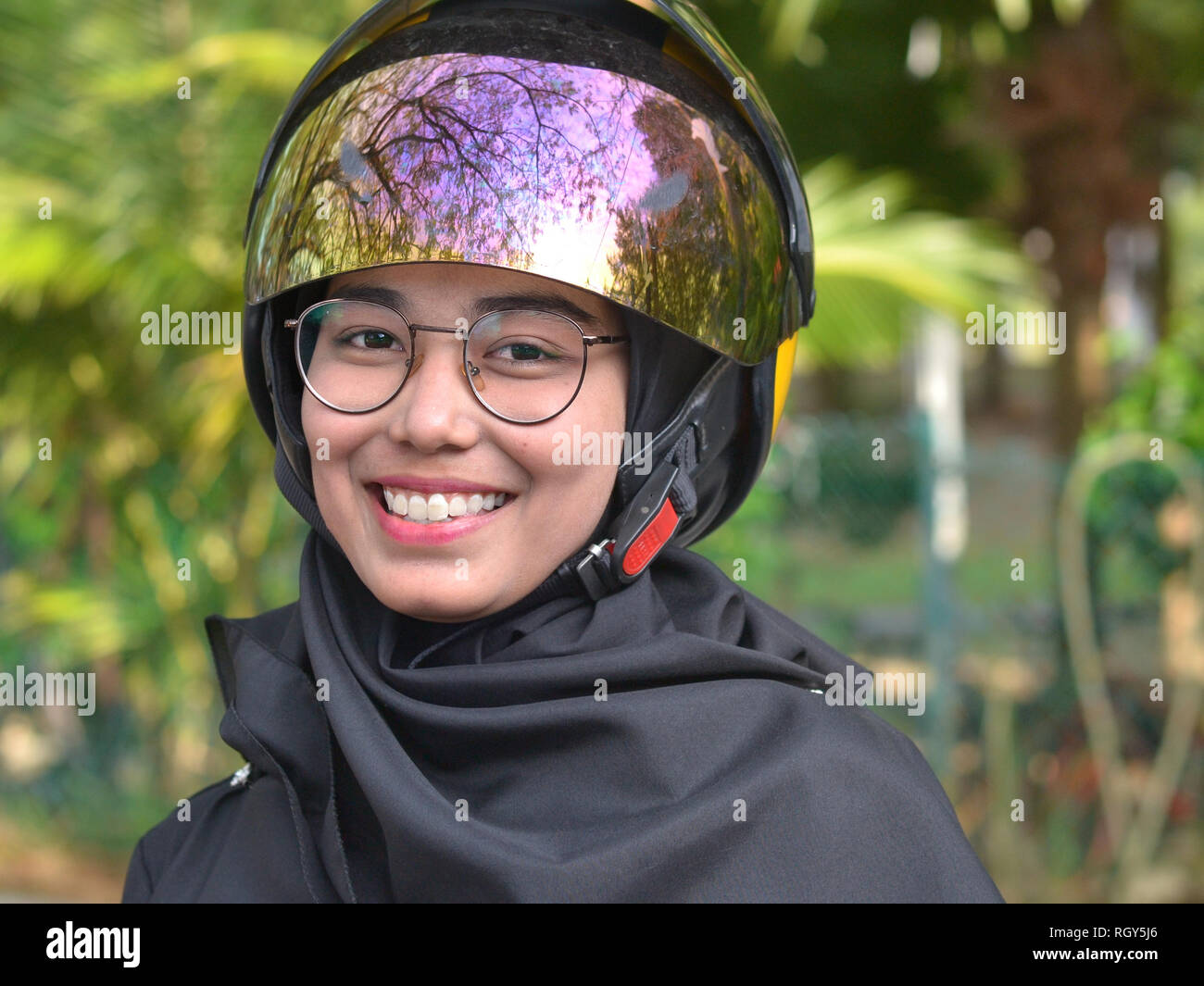 Jolie fille Malais musulmans avec lunettes porte un casque de moto moderne  sur son hijab traditionnel Photo Stock - Alamy