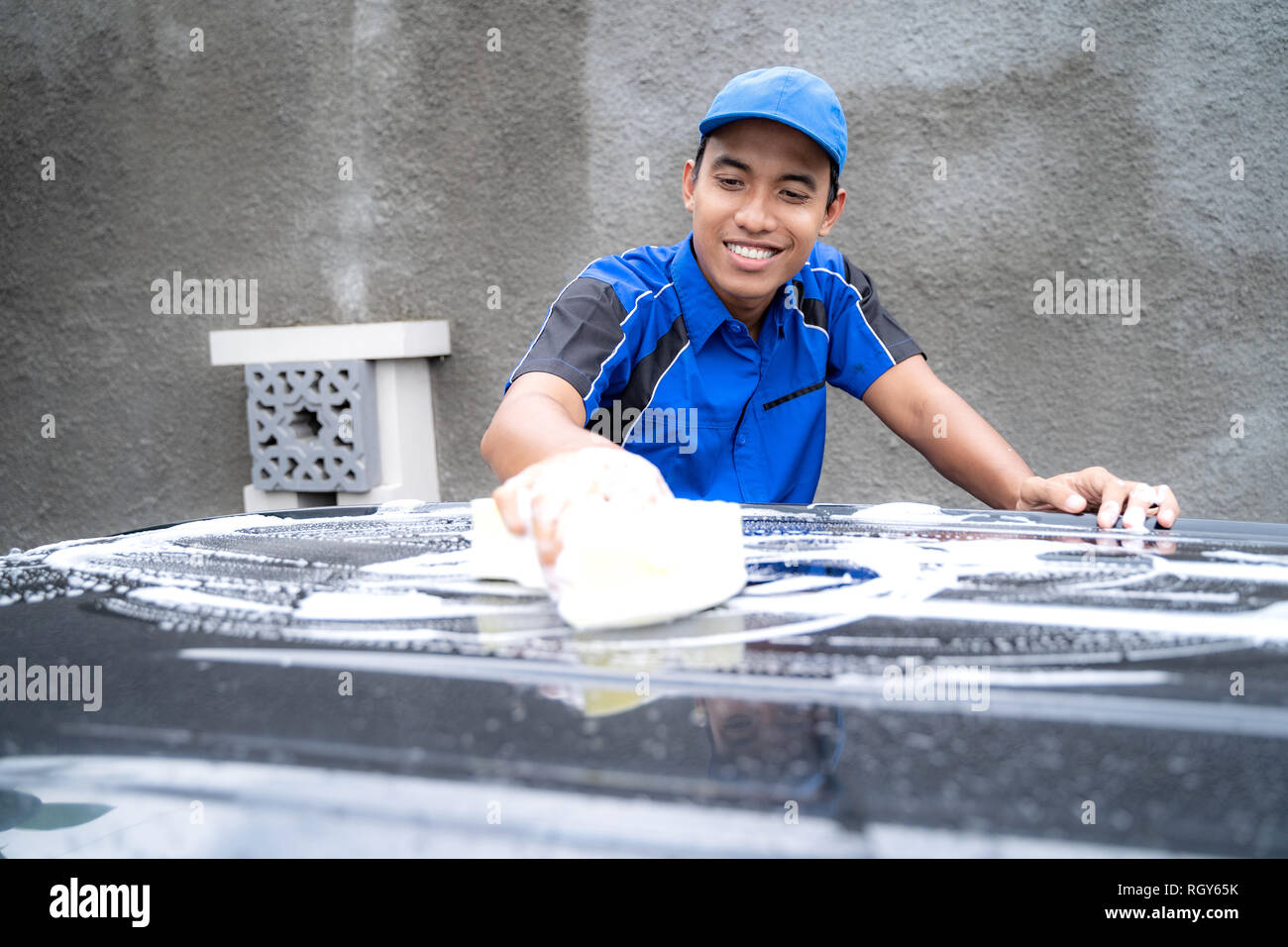Auto service personnel en uniforme bleu voiture nettoyage Banque D'Images