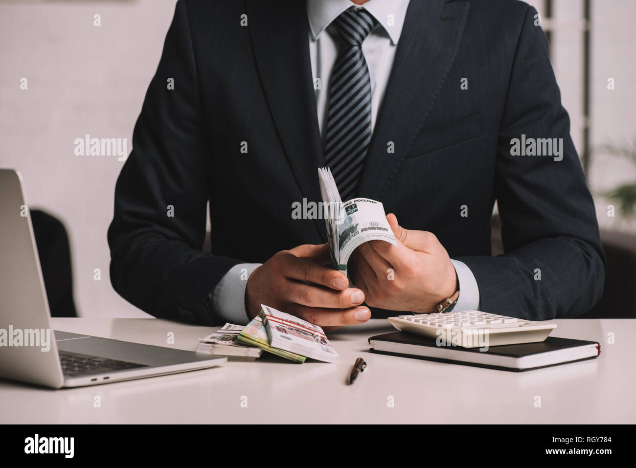 Mid section of woman in suit en comptant les billets de roubles russes sur le lieu de travail Banque D'Images