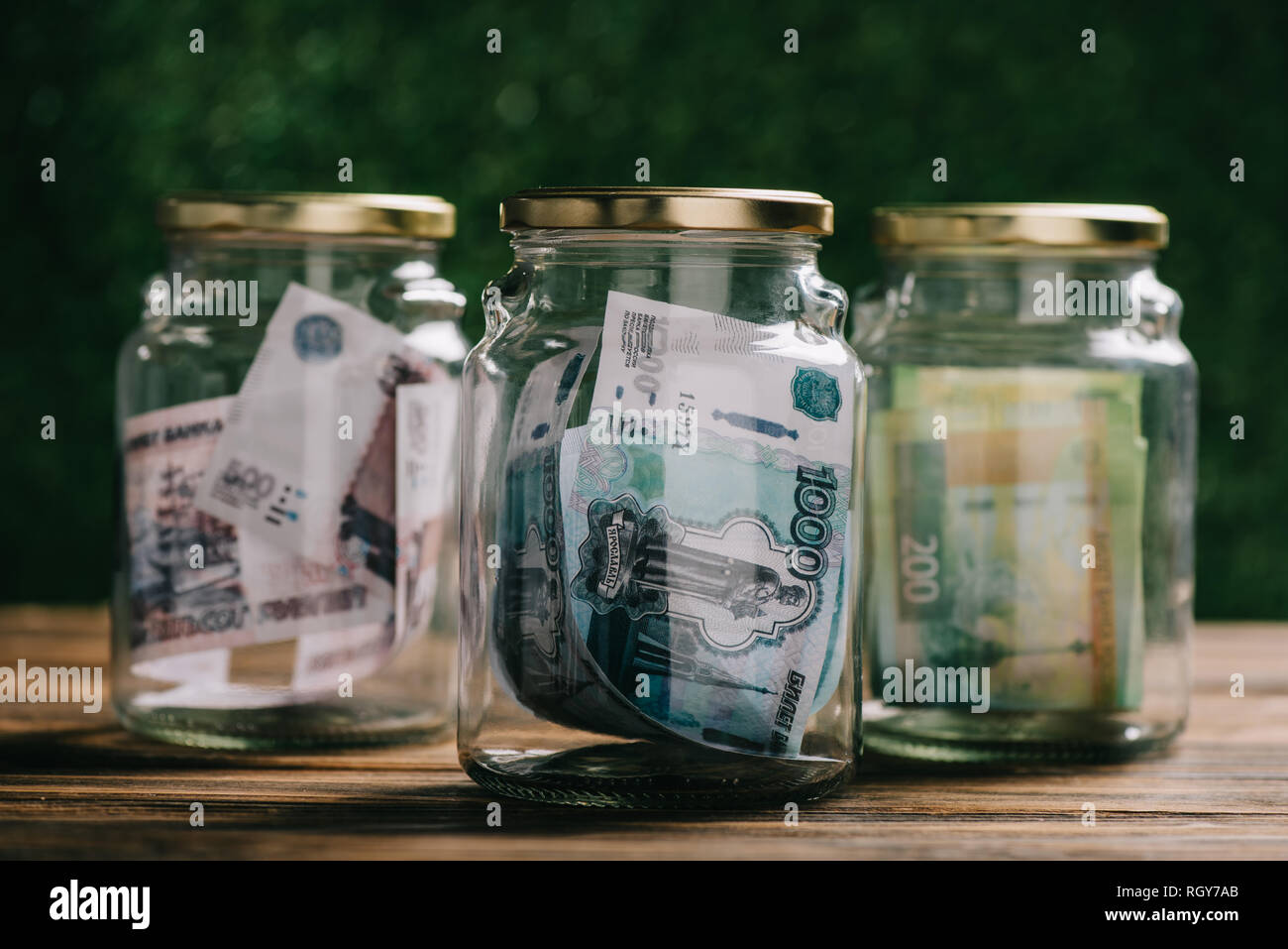 Vue rapprochée d'un bocal en verre avec des billets en roubles russes sur table en bois Banque D'Images