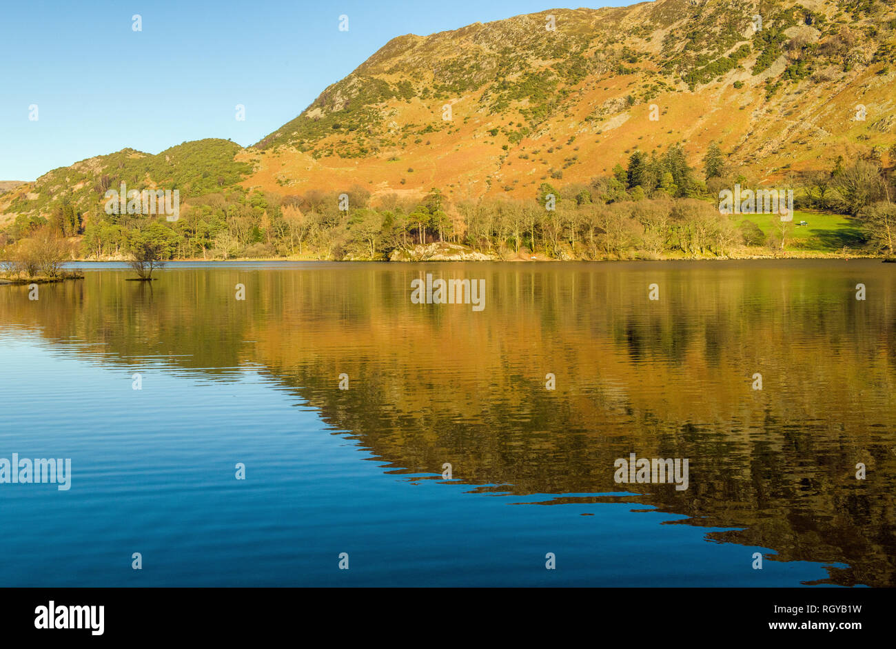 L'ensemble de Ullswater Glenridding dans le Parc National du Lake District, Cumbria sur une lumineuse et ensoleillée journée d'hiver. Réflexions de la claire à proximité fells. Banque D'Images