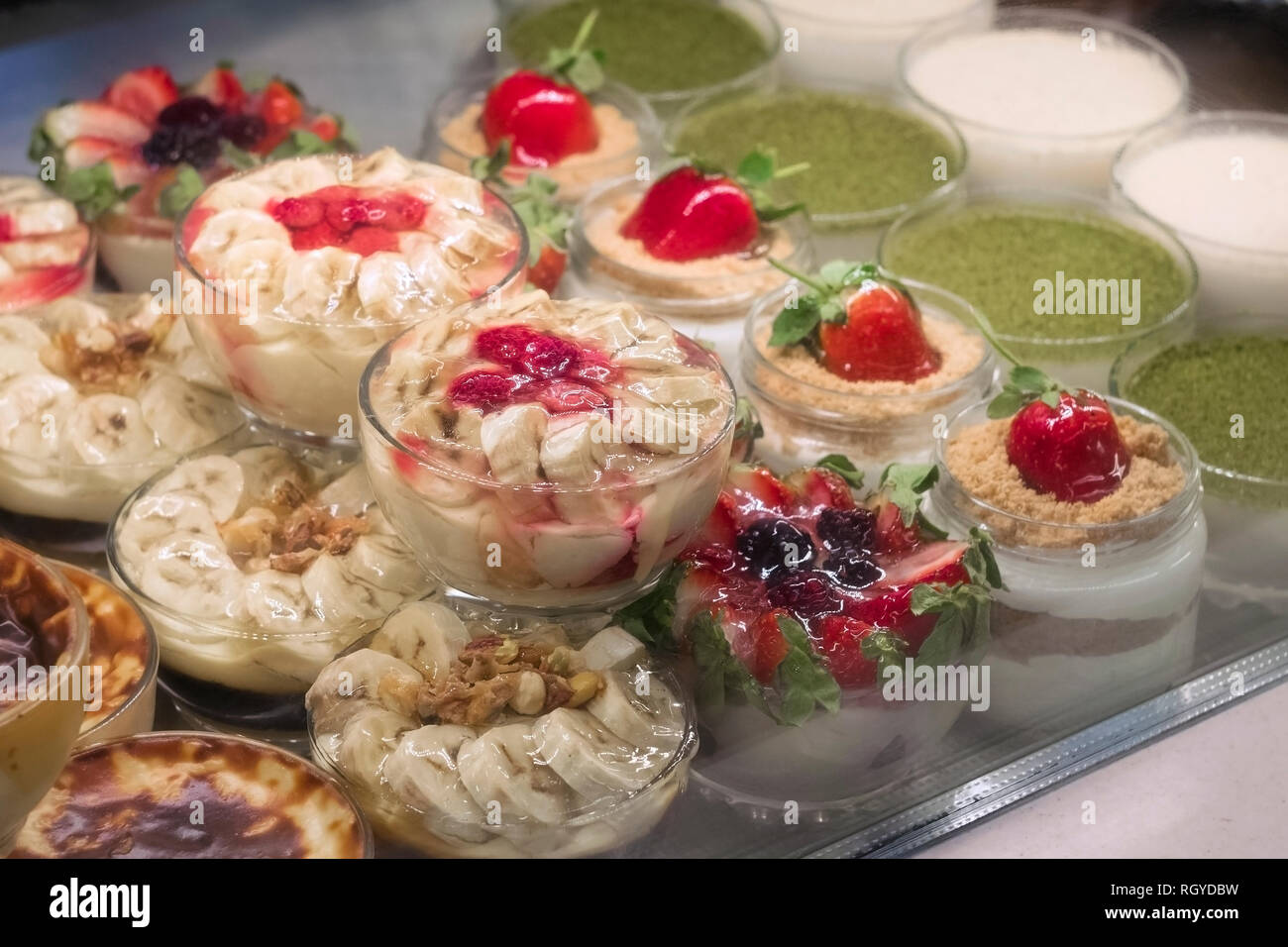 Les puddings aux fruits dans le verre à la fenêtre d'affichage de la boulangerie Banque D'Images