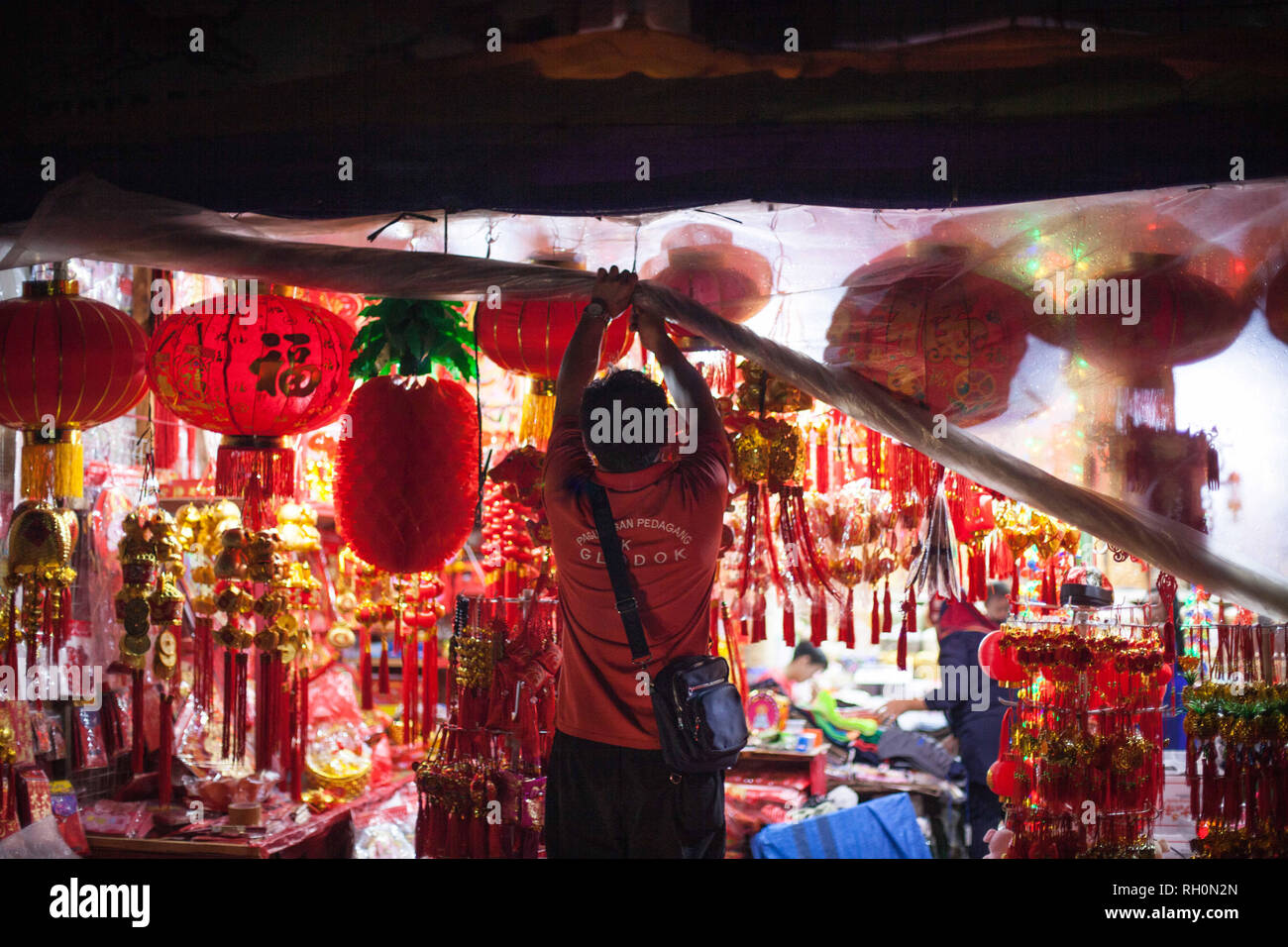 Jakarta, Jakarta, Indonésie. Jan 31, 2019. Un commerçant ouvrir le rideau en plastique après la pluie à un magasin qui vend des décorations du Nouvel An chinois dans le quartier chinois de Jakarta, Indonésie le 31 janvier 2019. Les gens d'origine chinoise dans le pays le plus peuplé du pays musulmans se préparent à célébrer le Nouvel An lunaire du cochon le 5 février. Afriadi Hikmal Crédit : Fil/ZUMA/Alamy Live News Banque D'Images