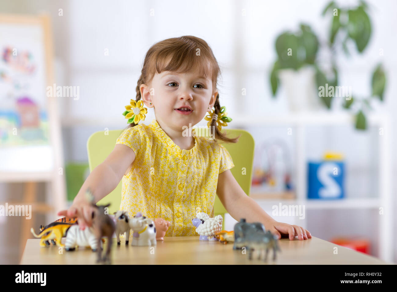 Portrait de jeune fille jouant avec des enfants joyeux, statuette d'animaux dans les jardins ou à la maternelle Banque D'Images