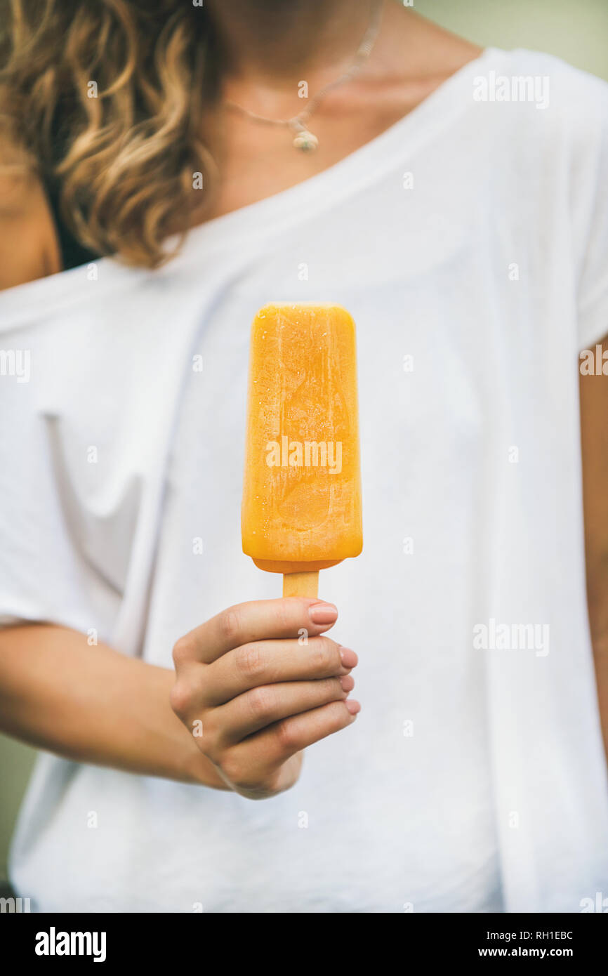 Agrumes Mango ice cream glace dans woman's hand Banque D'Images